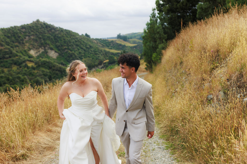 A wedding couple in the golden hills at Makoura Lodge, a destination wedding venue in the Manawatū